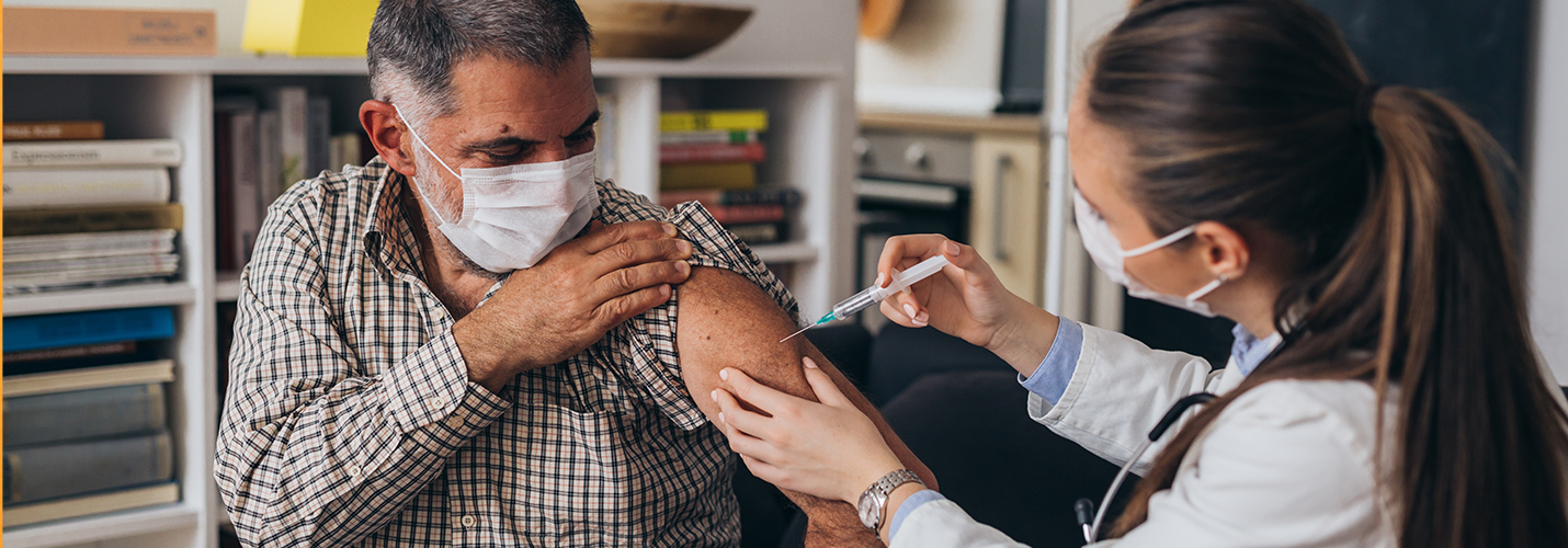 A person gets a flu shot by a doctor.