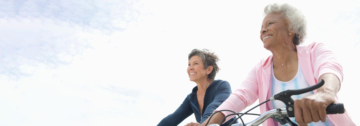 Two women ride bikes and exercise for their health.