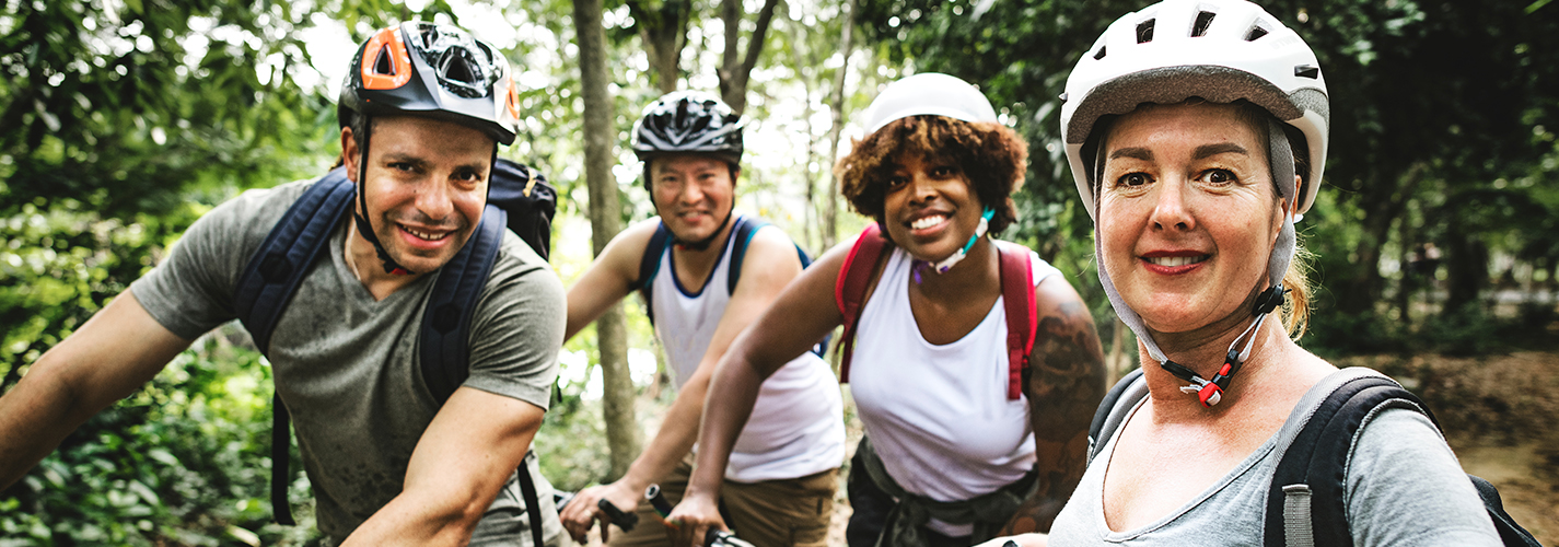 A group of friends takes a break while mountain biking in the woods.