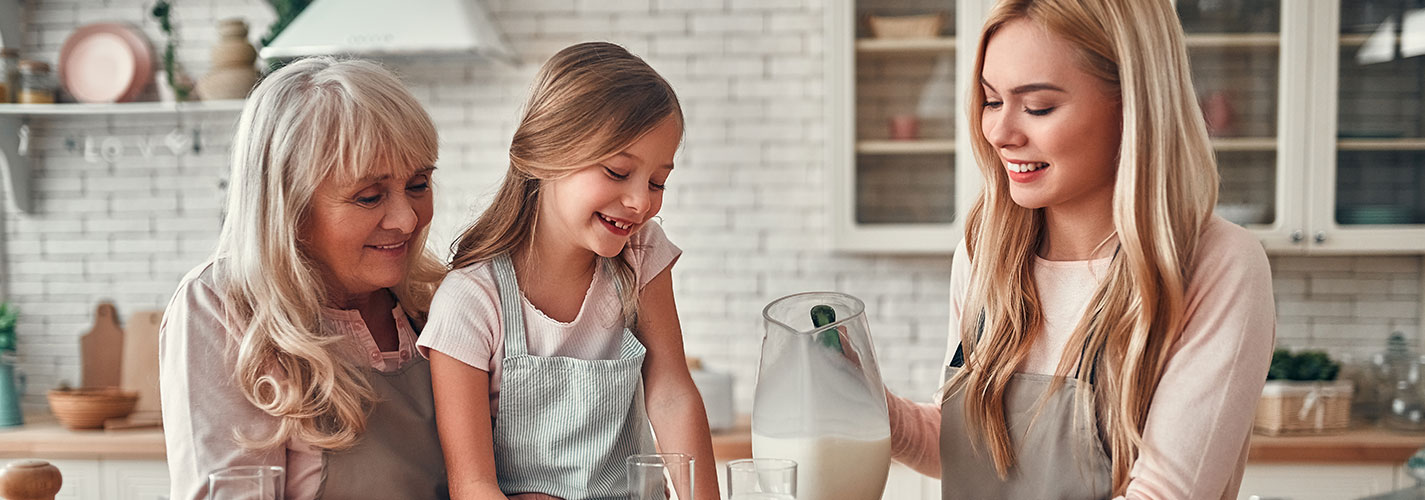 A grandmother, daughter, and granddaughter are baking in the kitchen together.