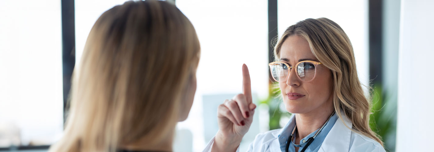 An ophthalmologist performs an eye exam on a female patient.