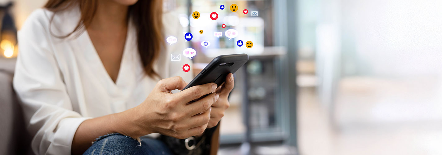 Woman using a smartphone with social media icons floating above the screen.