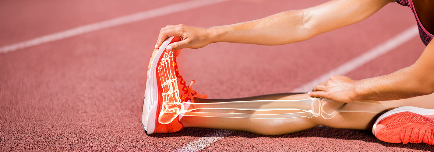 Person stretching on a track with a bone overlay showing the foot and leg skeleton.